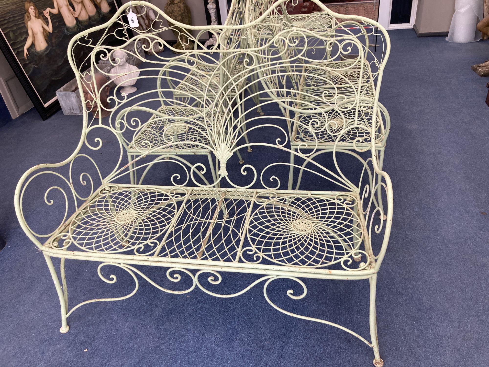 A French painted wrought iron garden suite comprising a pair of benches, length 122cm, depth 62cm, height 108cm, a pair of chairs and a table